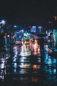 Picture of a dark rainy alleyway lit by neon